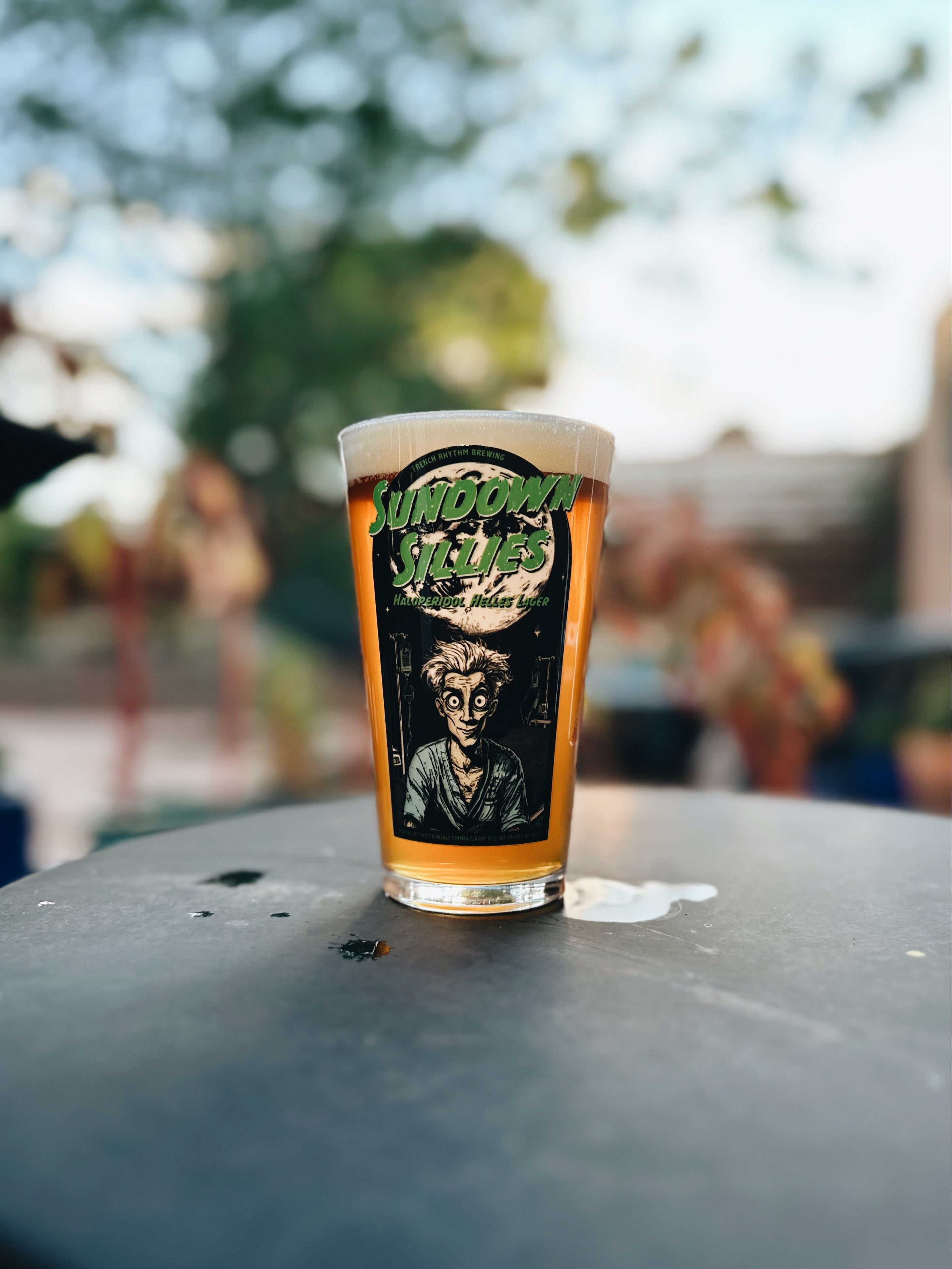 Pint of beer with a label on a table outdoors
